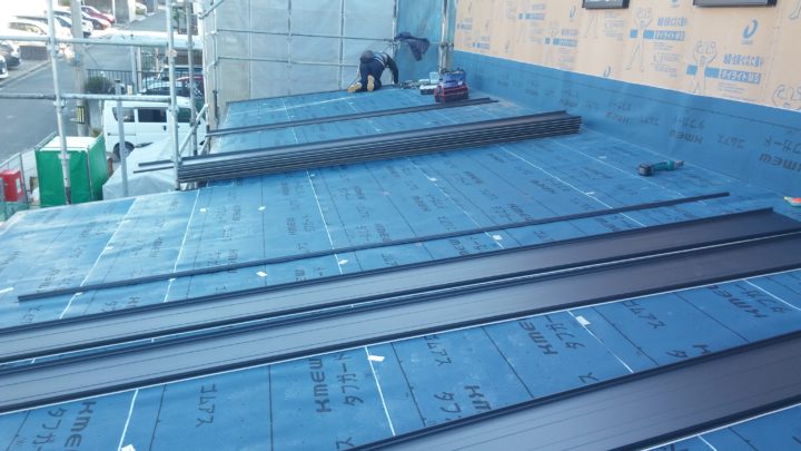 屋根工事。ガルバリウム鋼板葺きの施工風景です。今回はブラック色を採用。壁が白なのでとてもメリハリがありスッキリしています。